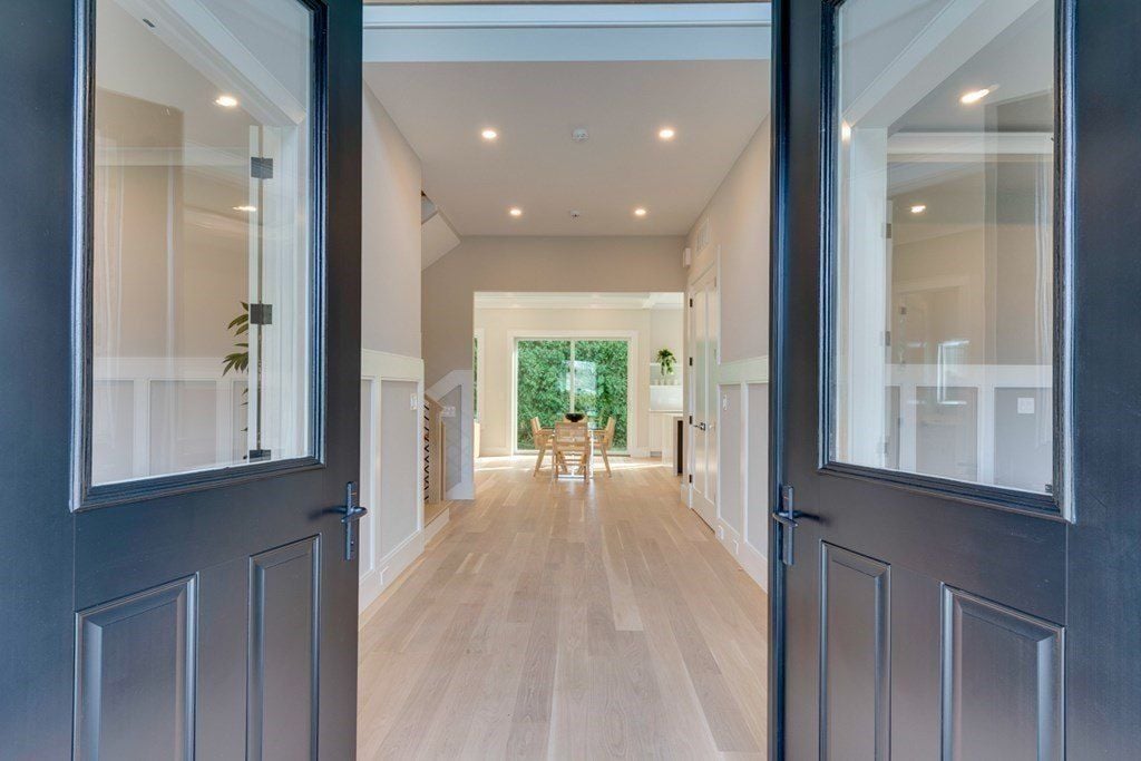 The entrance features double doors with insulation, and the wooden flooring gives off a welcoming feel.