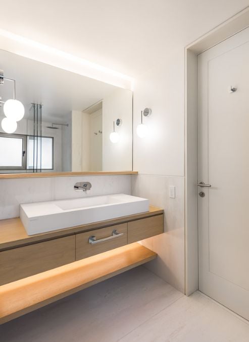 A bathroom which contains a sink and a mirror that form a fundamental aspect of a functional bathroom.