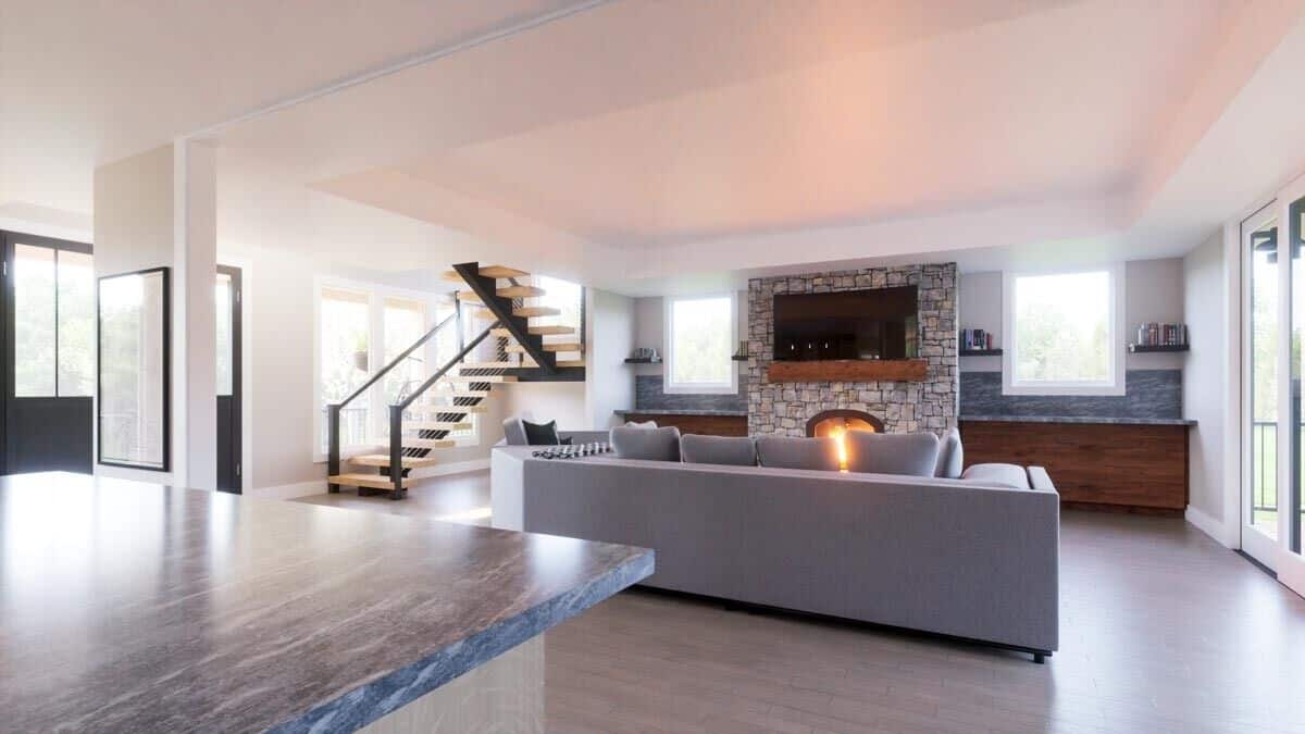 A stone fireplace topped with a floating shelf and TV warms the living room.