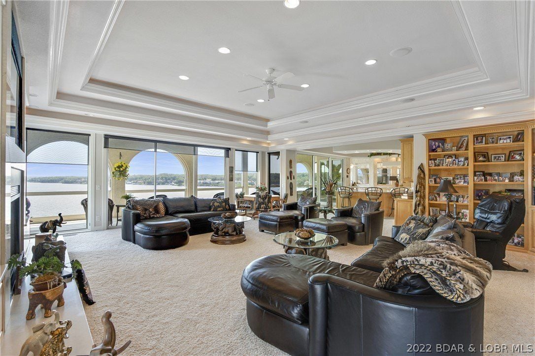 The living room features leather sofas and a wall-to-wall carpet giving off a cozy feel.