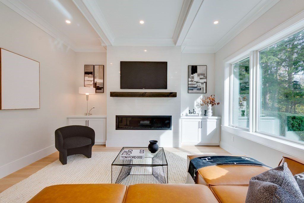 The living room features an electric fireplace and insulated glass windows that showcase the view outside.