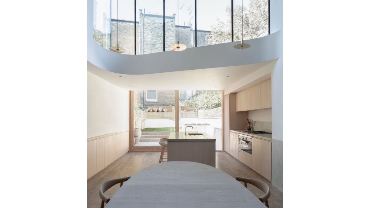 The dining room and kitchen are located below the reception areas and are connected by the house's entrance.
