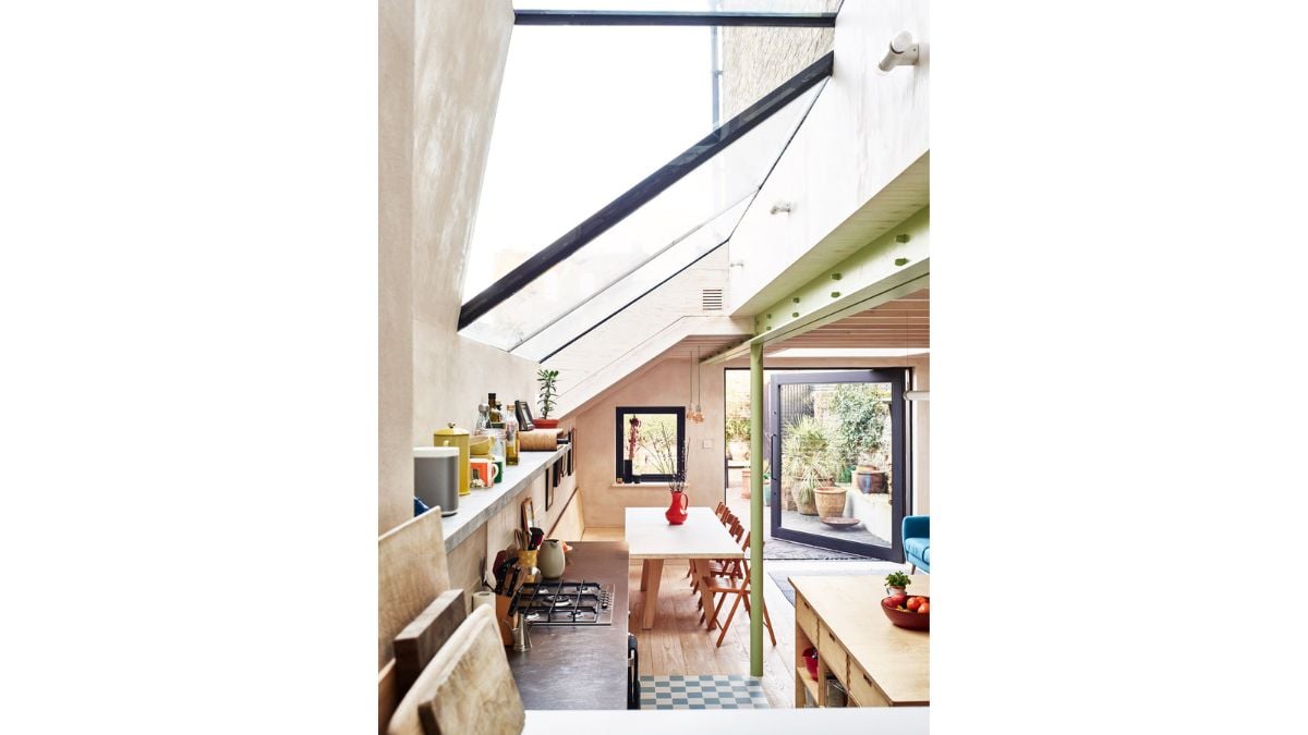 The structural glazing above the kitchen extends up to envelop the existing sash window where the expansion meets the house.