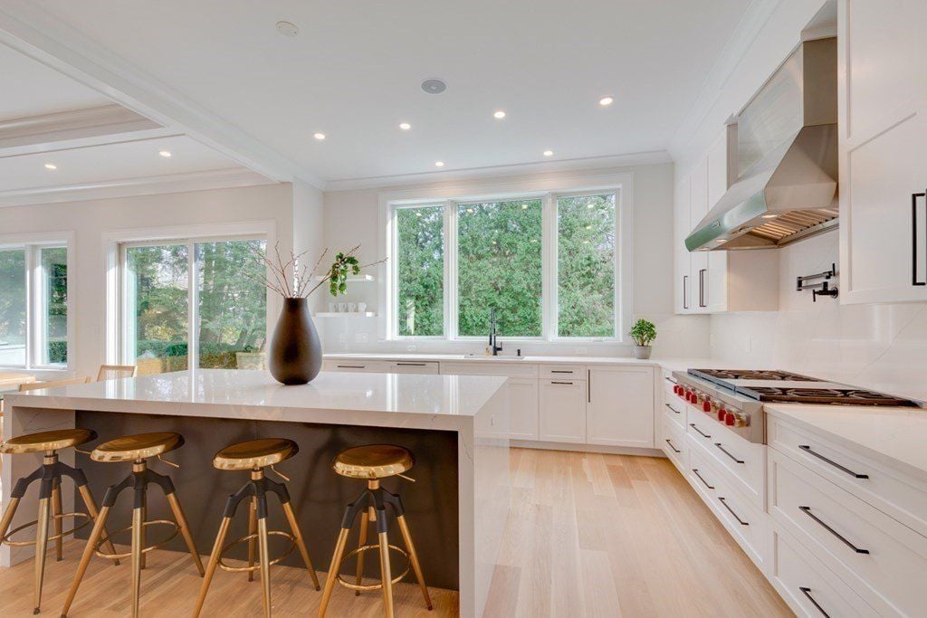 The kitchen with an L-shaped layout features a bi-level kitchen island with a tile countertop.