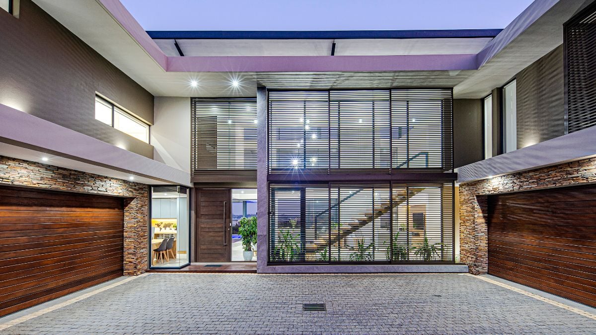 The point of arrival is a sizable, three-sided, double-volume courtyard with entrance to four garages and guest parking.