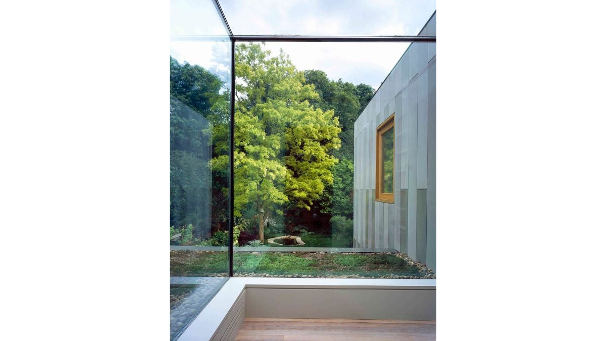 A frameless glass box upstairs provides views of the garden over a green roof and illuminates the existing circulation corridor with light.