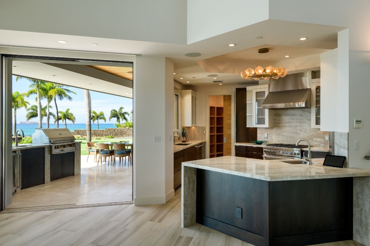 The house features a gourmet kitchen with a kitchen bar and has direct access to the outdoor kitchen.