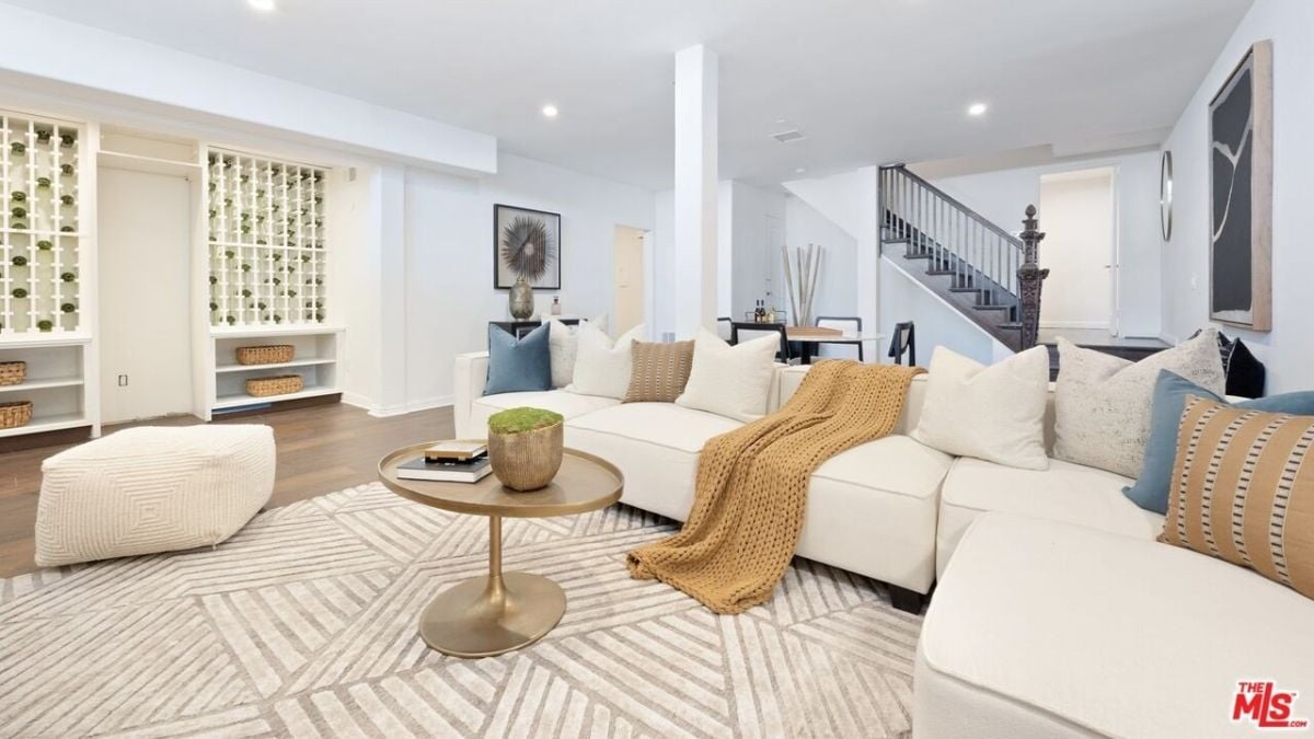 The lounge features an l-shape sofa and an area rug that blends well with the center table.