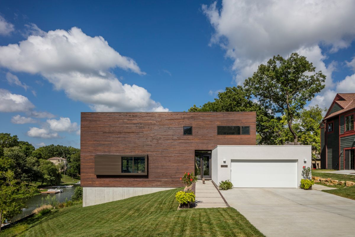 The house is two simple platonic forms, one resting on the other, pulled apart to create an aperture to the lake.