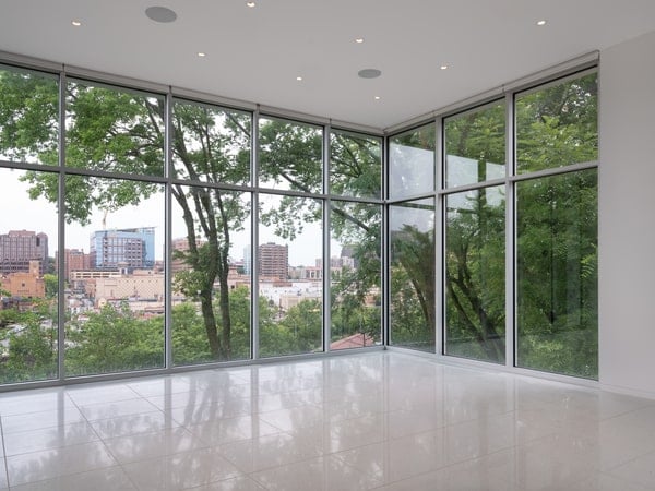 The main living spaces and master suite rest on the foundation as a white stucco wrap that is opaque against its neighbors while open to the street and Plaza views.