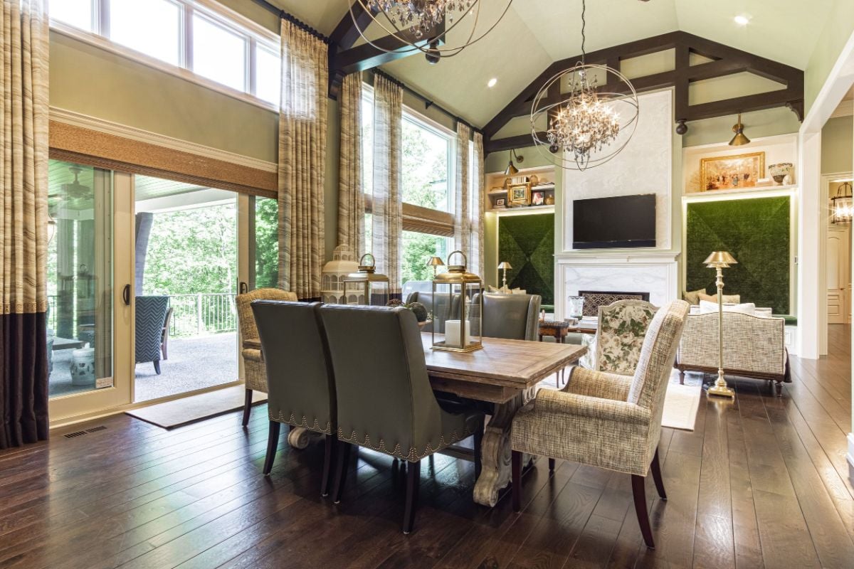 The dining area features a wooden table and a chandelier that gives off a luxurious feel to the room.