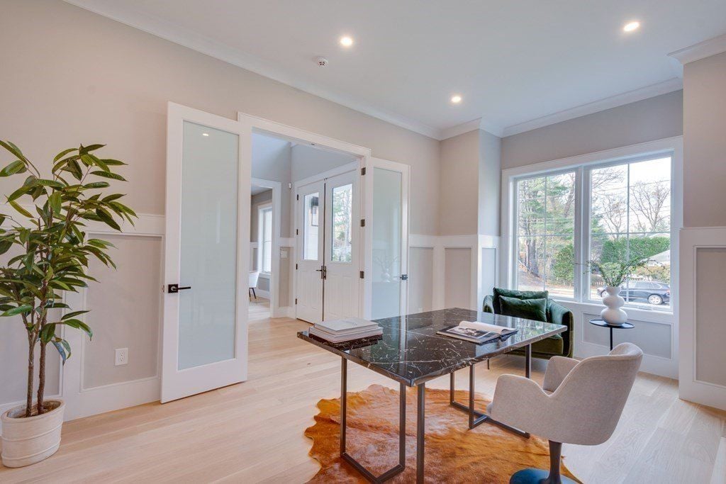 The study features a table with a tile top and an area rug that blends well with the flooring.