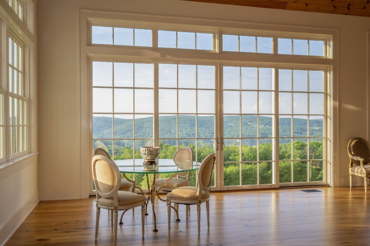 The dinette features a round glass table, and the glass door showcases the view of the lake.