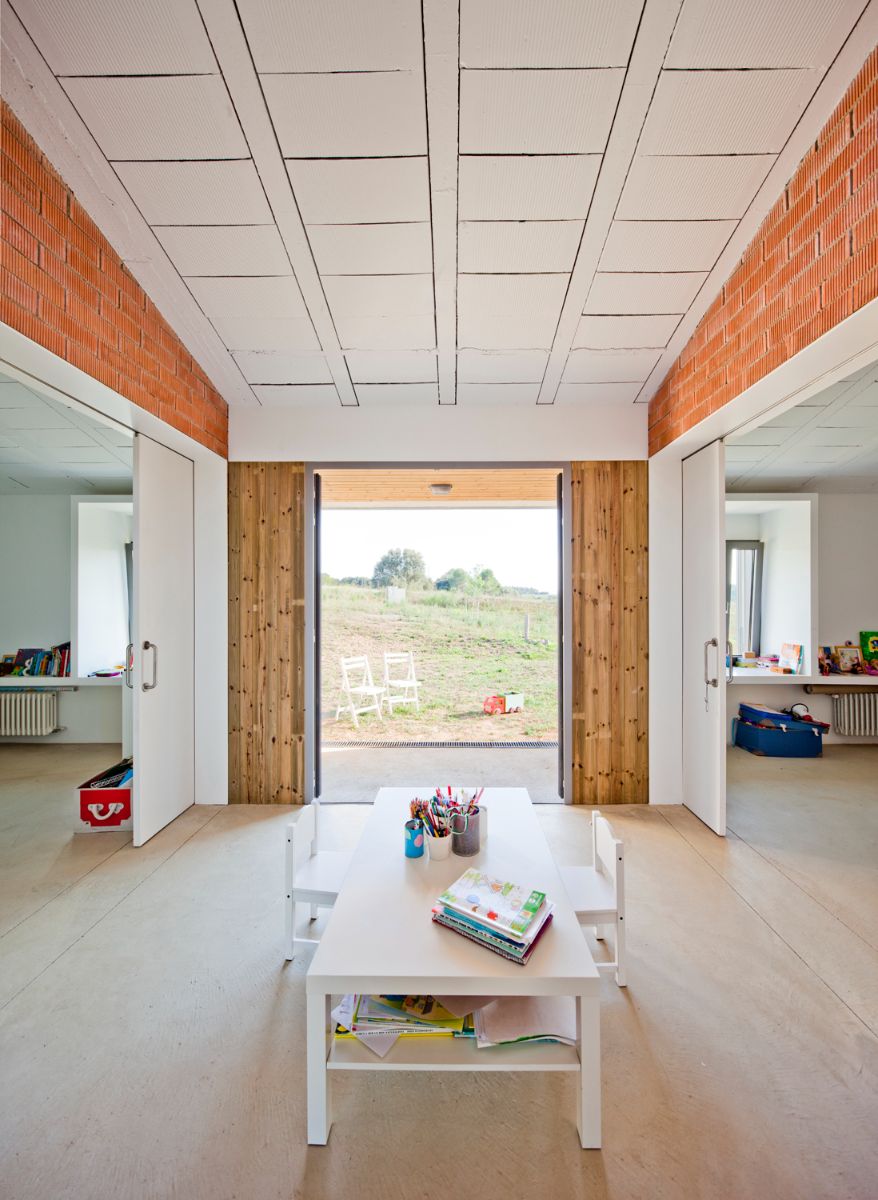 The children's room, located between the main living room and the kitchen, has a huge glass window with a view of the large garden outside.