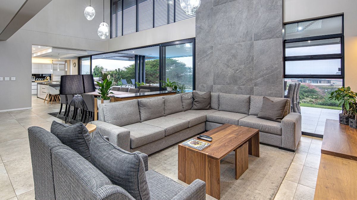 The living room is decorated in a minimalistic manner, and the wooden center table gives it an industrial air.