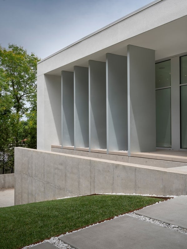 Sun studies at the street side inform the setback of the front façade to reduce heat gain and protect the art, while vertical fins on the west create privacy and protect against the setting sun.