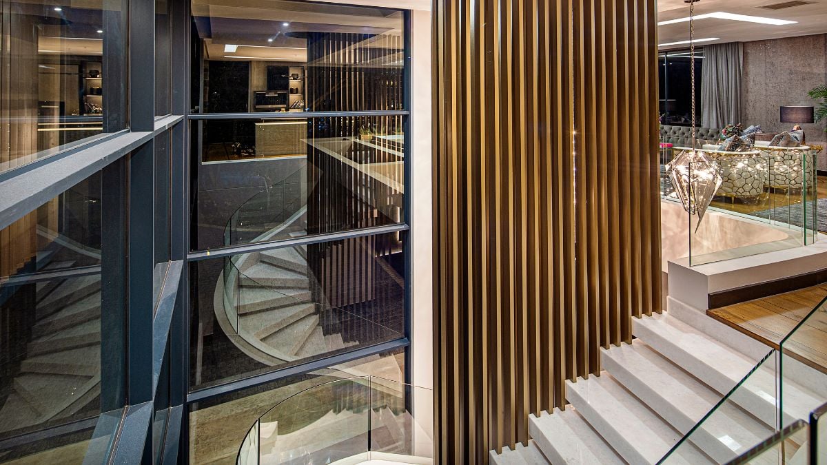 A closer look reveals that the home's big glass façades are hidden by an exoskeleton made of concrete and aluminum screens that is raised proud of the structure.