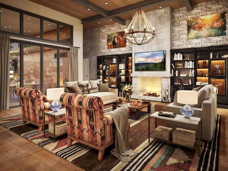 Cozy living room with warm decor, a stone fireplace, patterned armchairs, and built-in bookshelves.