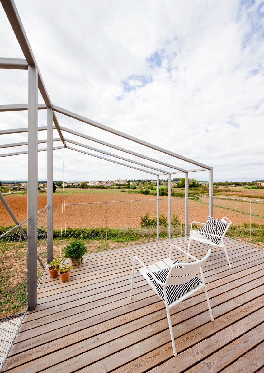 A deck with crossed views and circulations offer direct relationships to the landscape around the house.