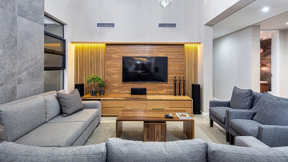 The room is made more engaging by the sofa that is facing the television and has a wooden design structure.