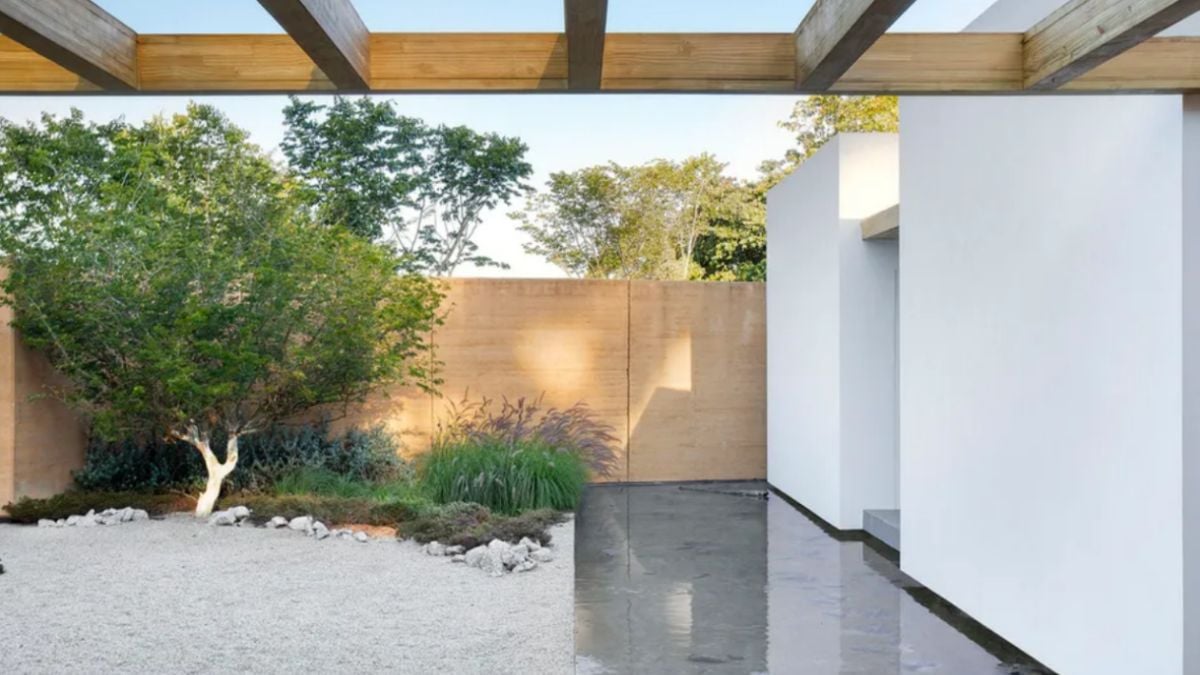 A landscape and sand are visible from the rear of the house.