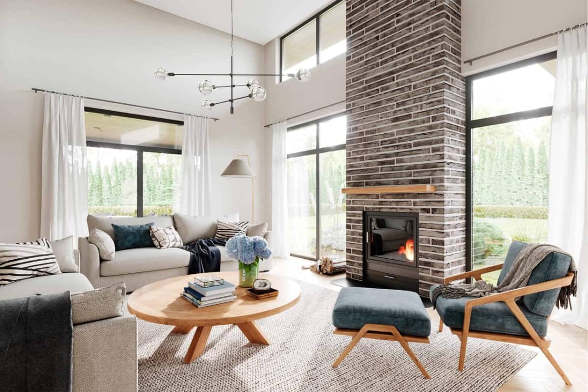 The living room features a vaulted ceiling and a brick fireplace flanked by sliding glass doors.