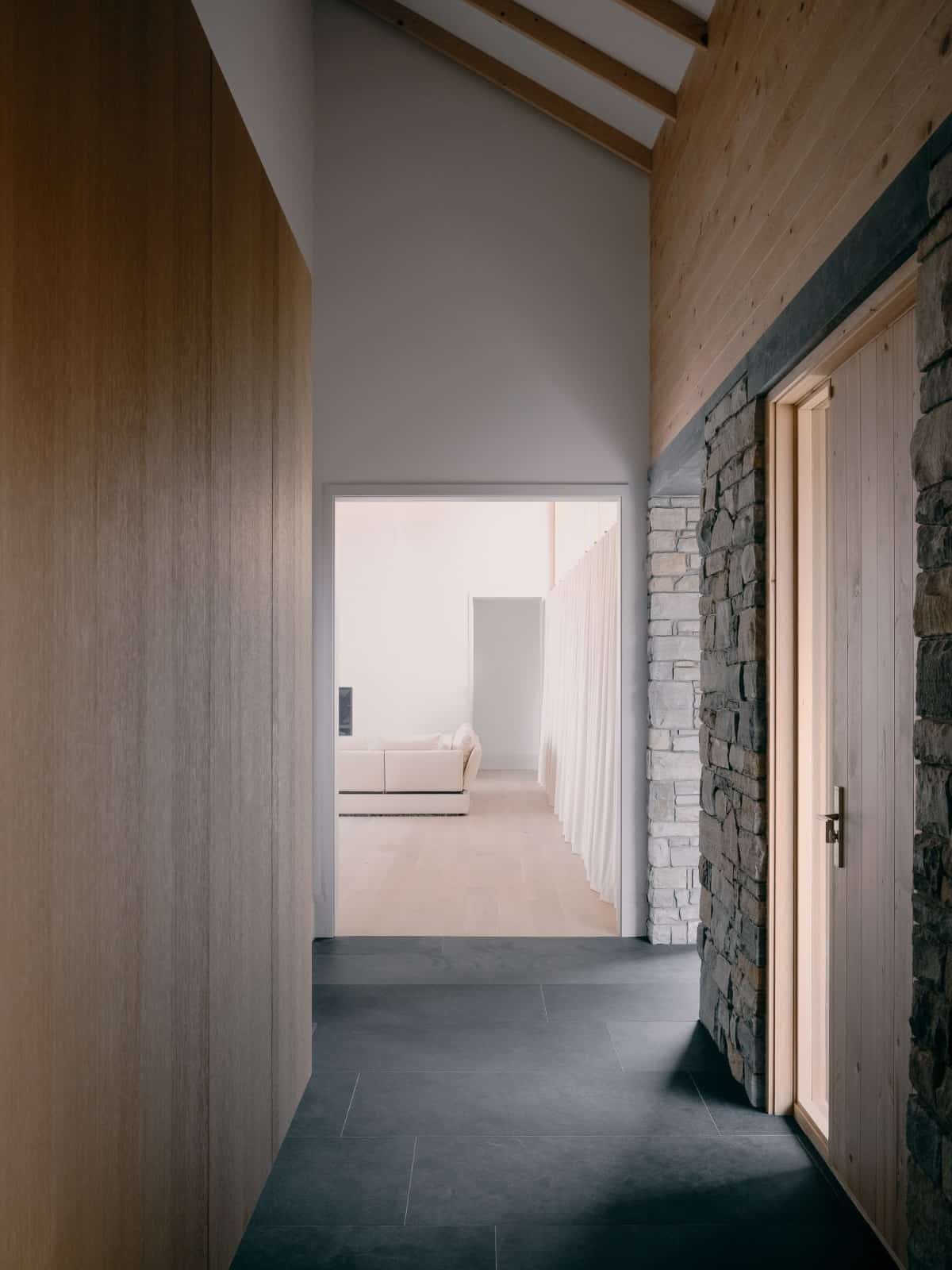 Entry hallway with concrete tiled flooring leading to the living room.