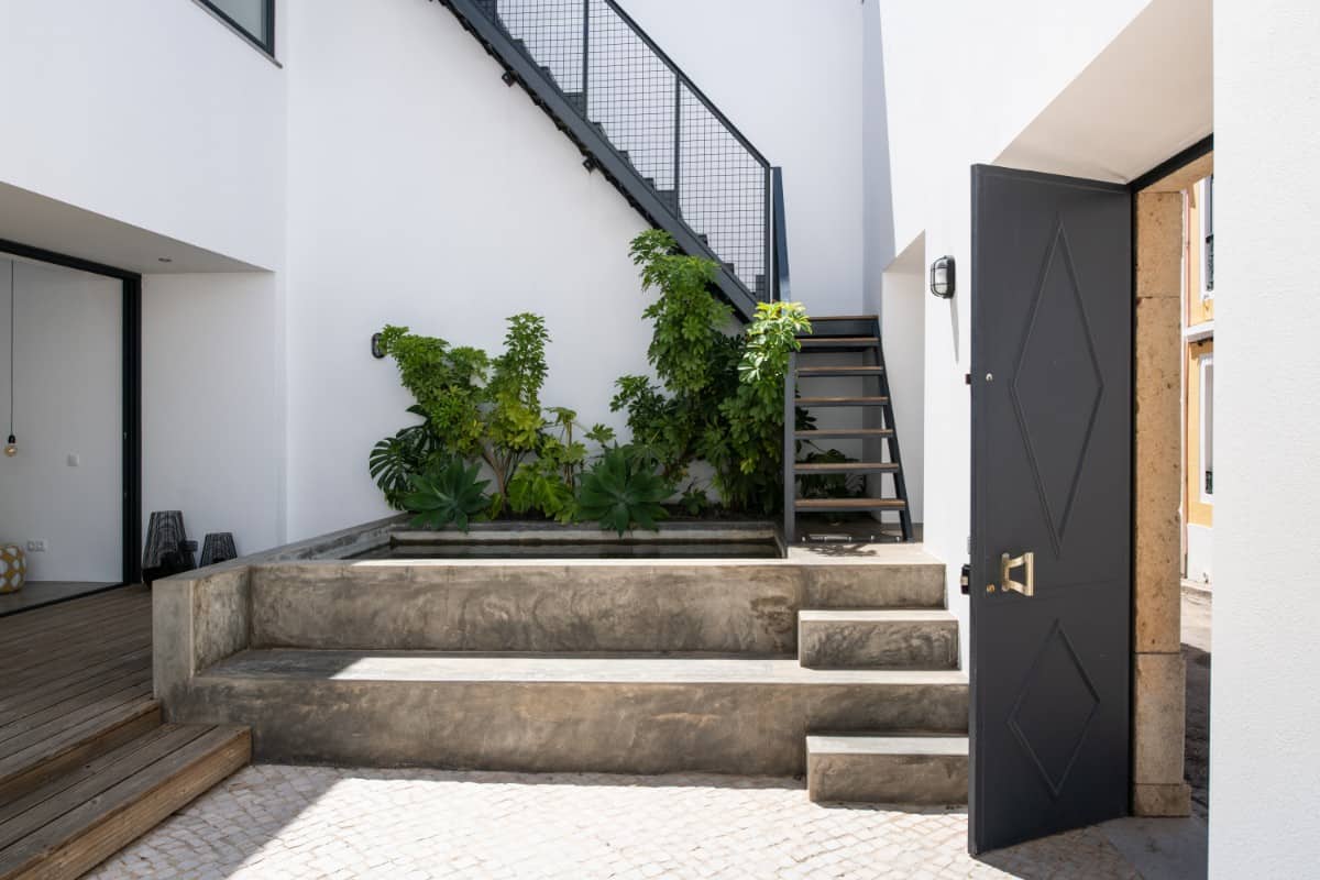 As you enter the home, you are greeted by a private courtyard with a staircase leading to the upstairs terrace.