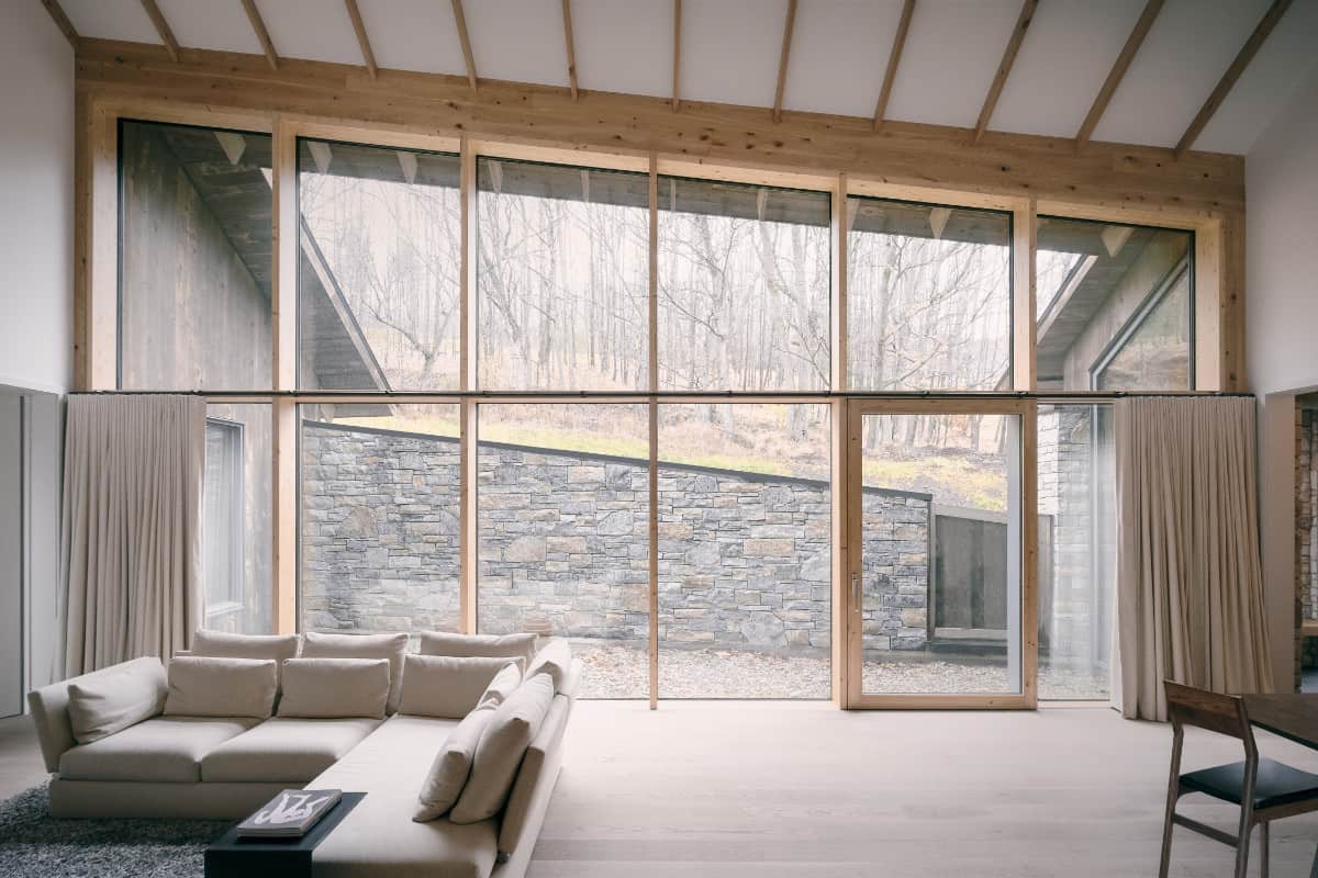 The living room features a shed ceiling and full-height glazing bringing an abundance of natural light in.