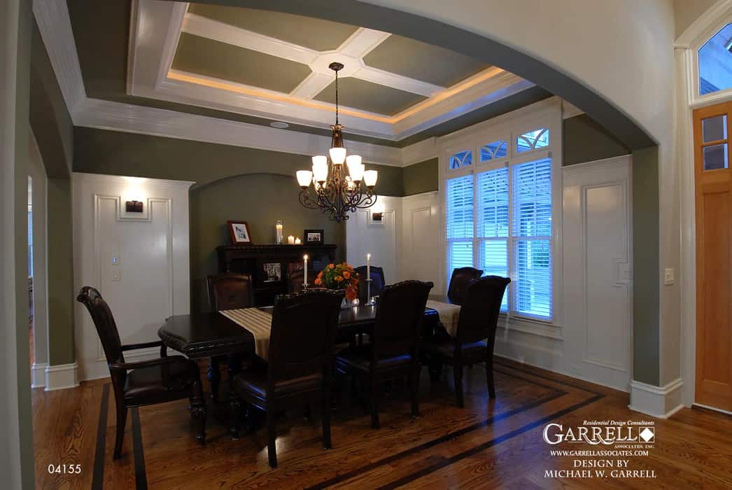 The formal dining room has a dark wood dining set, wainscoted walls, and a tray ceiling.