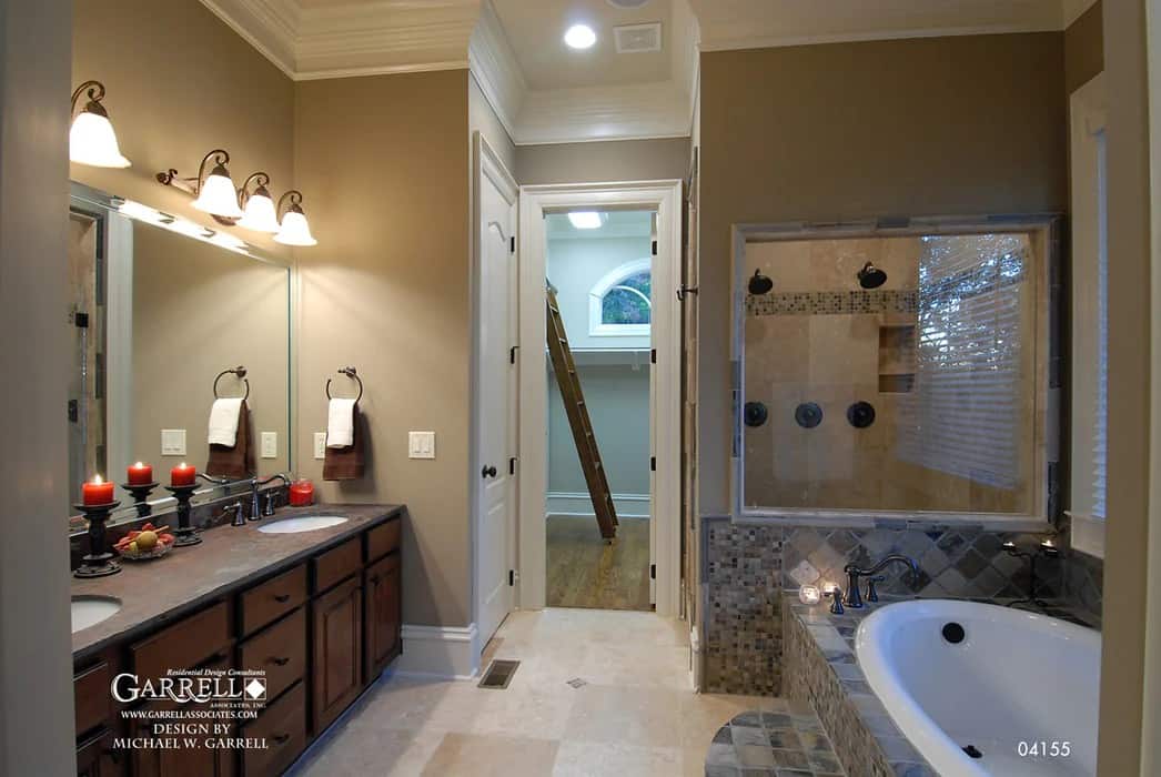 The primary bathroom is equipped with a dual sink vanity, a drop-in bathtub, a tiled shower, and a walk-in closet.