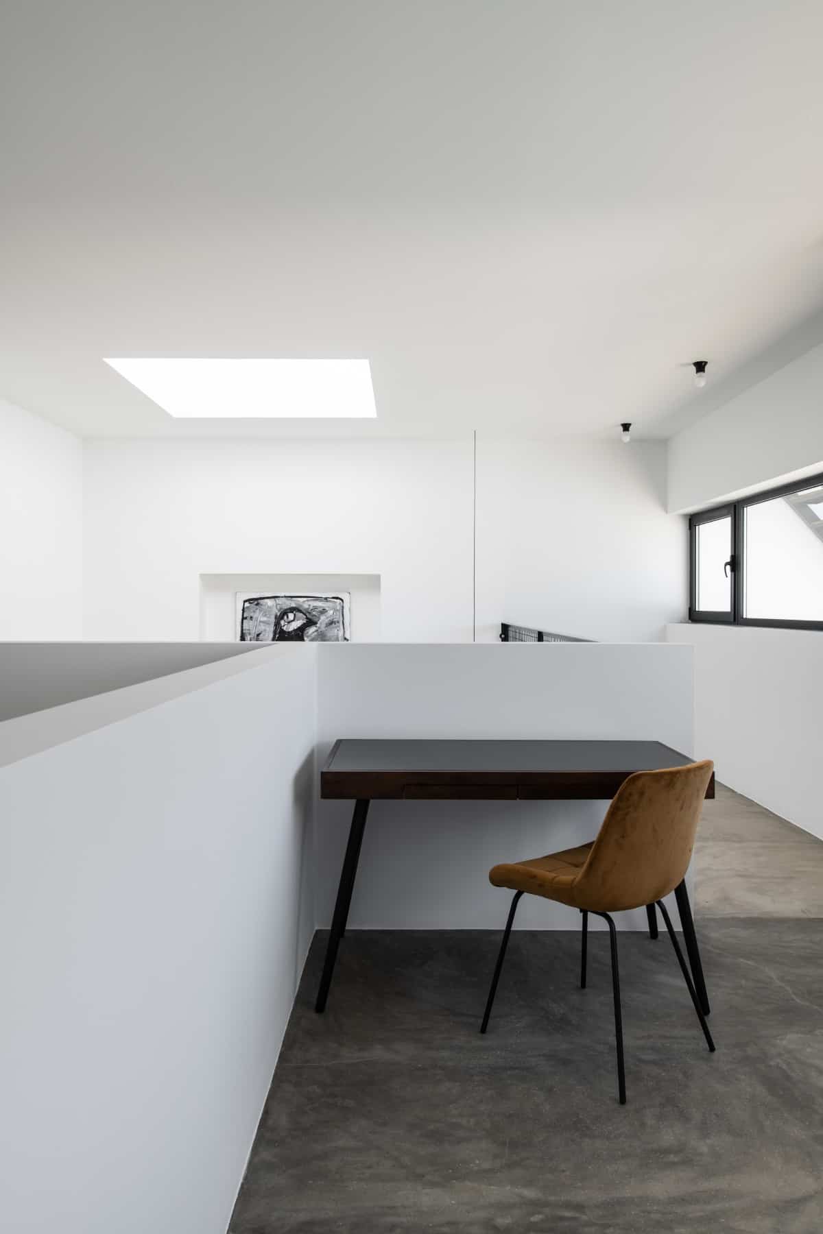 A skylight and aluminum-framed windows brighten the study area.