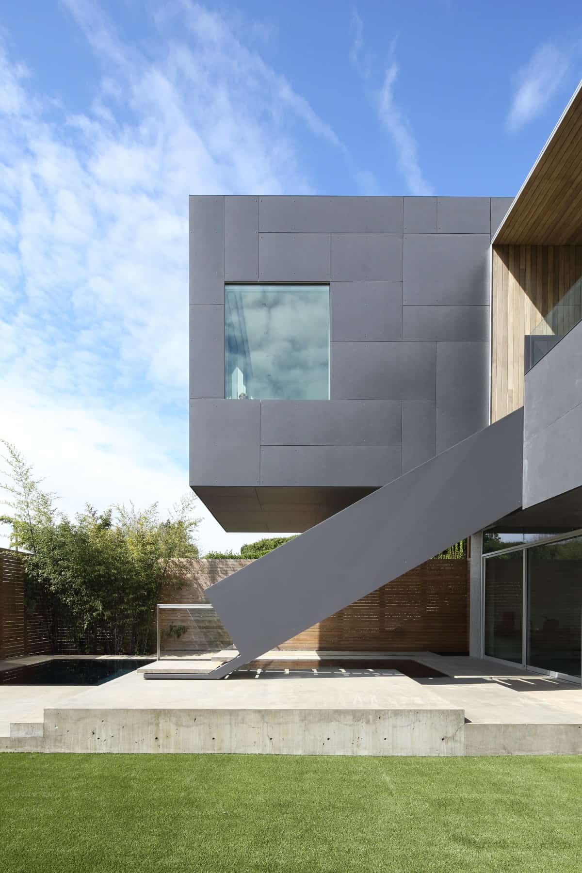 Exterior view of the house showcasing its cantilevered volume fitted with a sleek picture window.