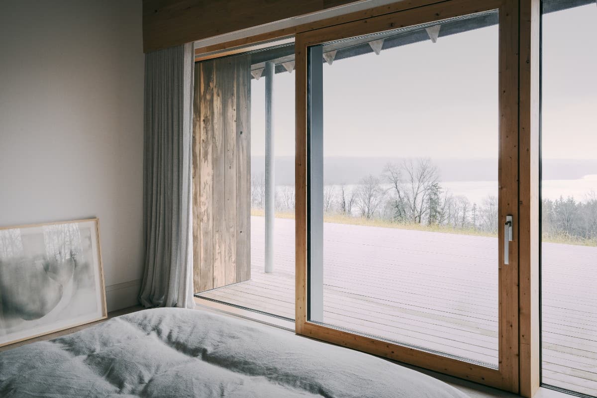 The bedroom includes an oversized sliding glass door that leads to an open deck.