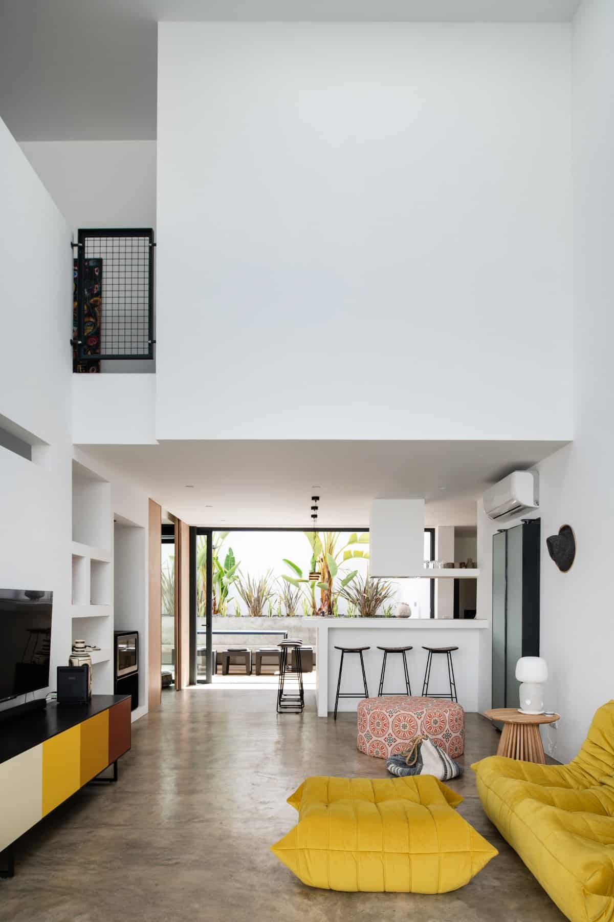 The living room features a tall ceiling that boosts the area's light and airy vibes.