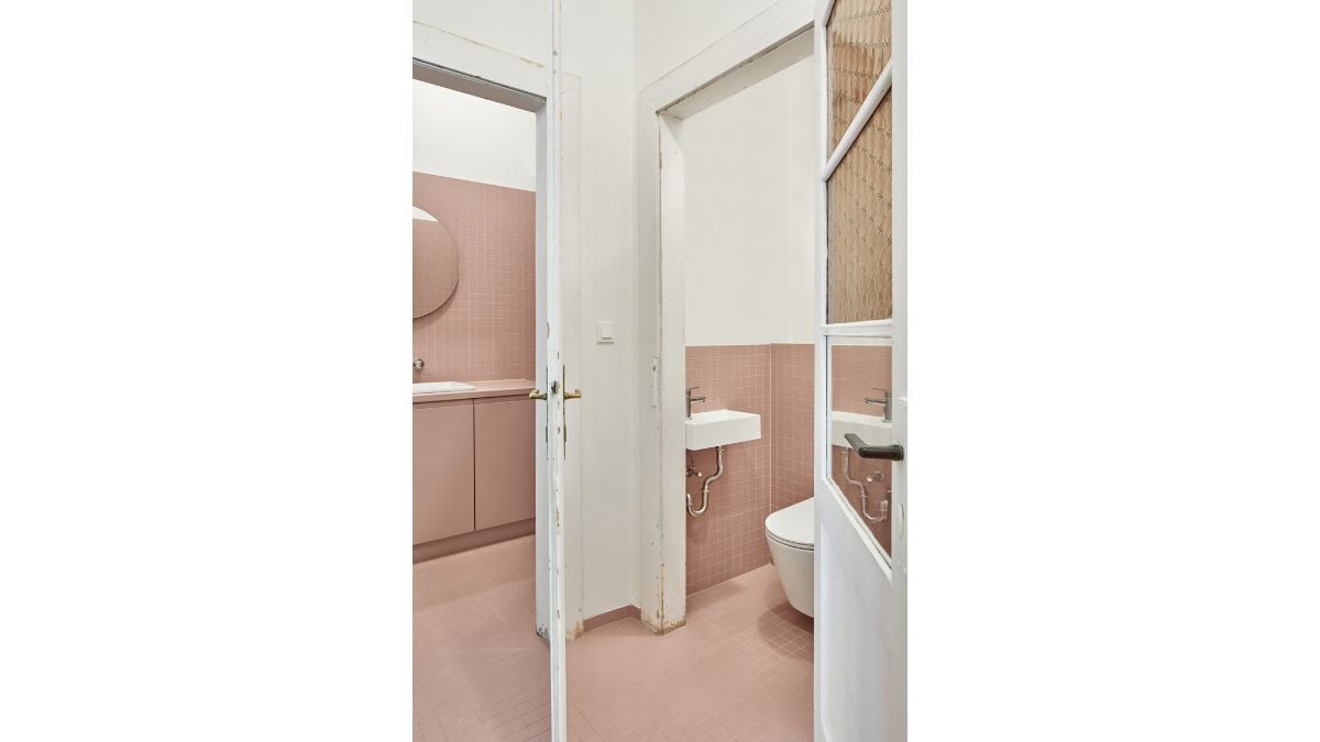 The bathroom's color scheme of pink and white works beautifully together.