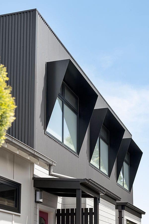 The house also features large front windows surrounded by dark timber cladding.