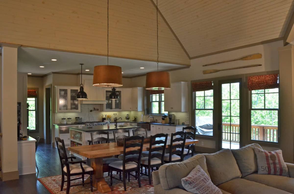 The dining area nestles between the kitchen and lodge room. It has a wooden dining set topped with oversized drum pendants.