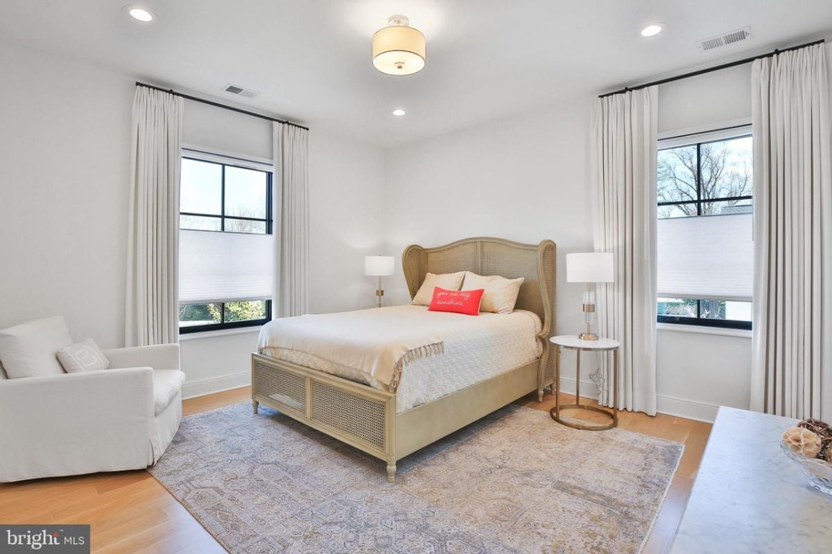 The spacious and luxurious bedroom was furnished with a plush bed which is situated on top of a soft and stylish area rug.
