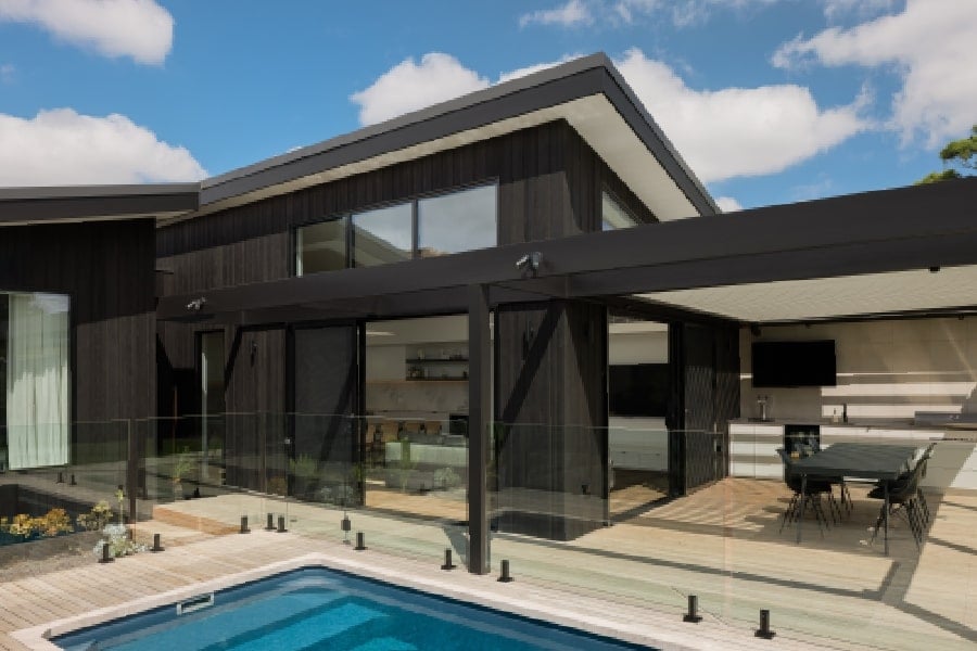 Exterior view with a contemporary pool and black timber cladding.