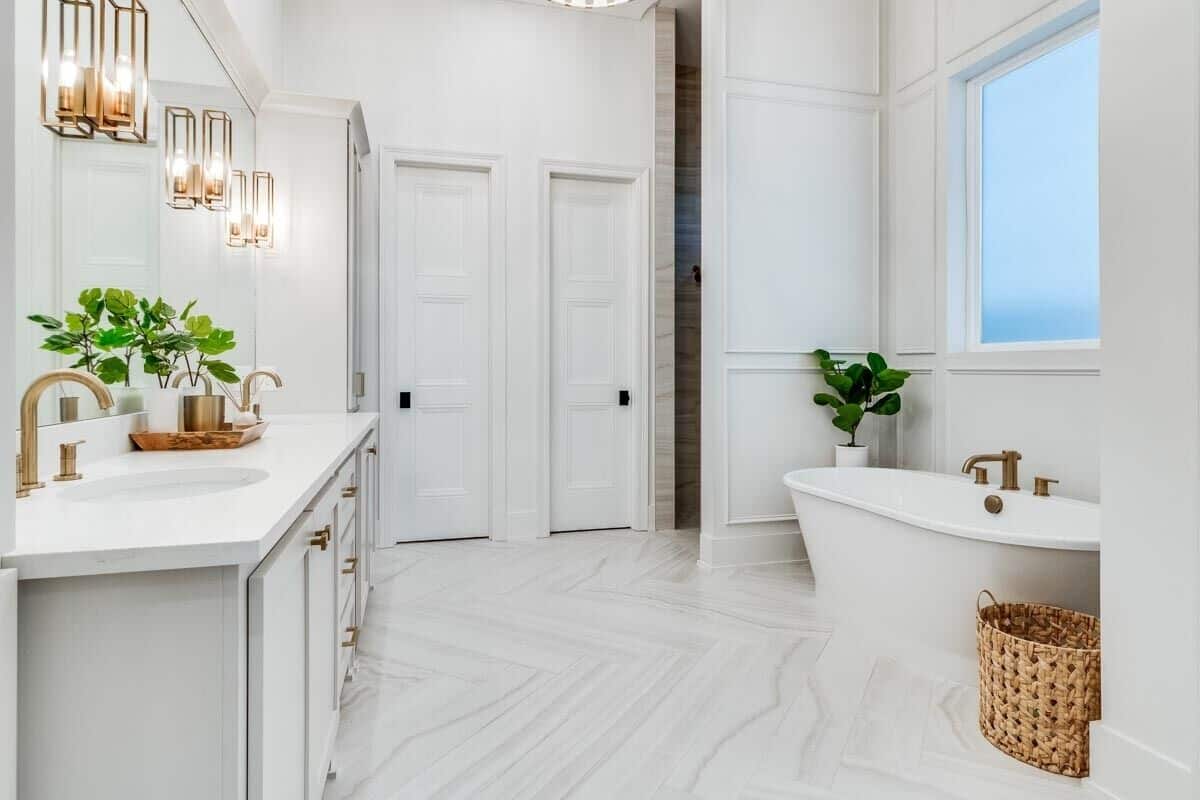Marble flooring along with brass hardware and fixtures add elegance to the primary bathroom.