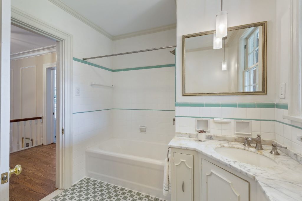 Tub/shower combo in the hall bathroom with Tennessee marble countertop. Original tile flooring and handsome tile trim work.