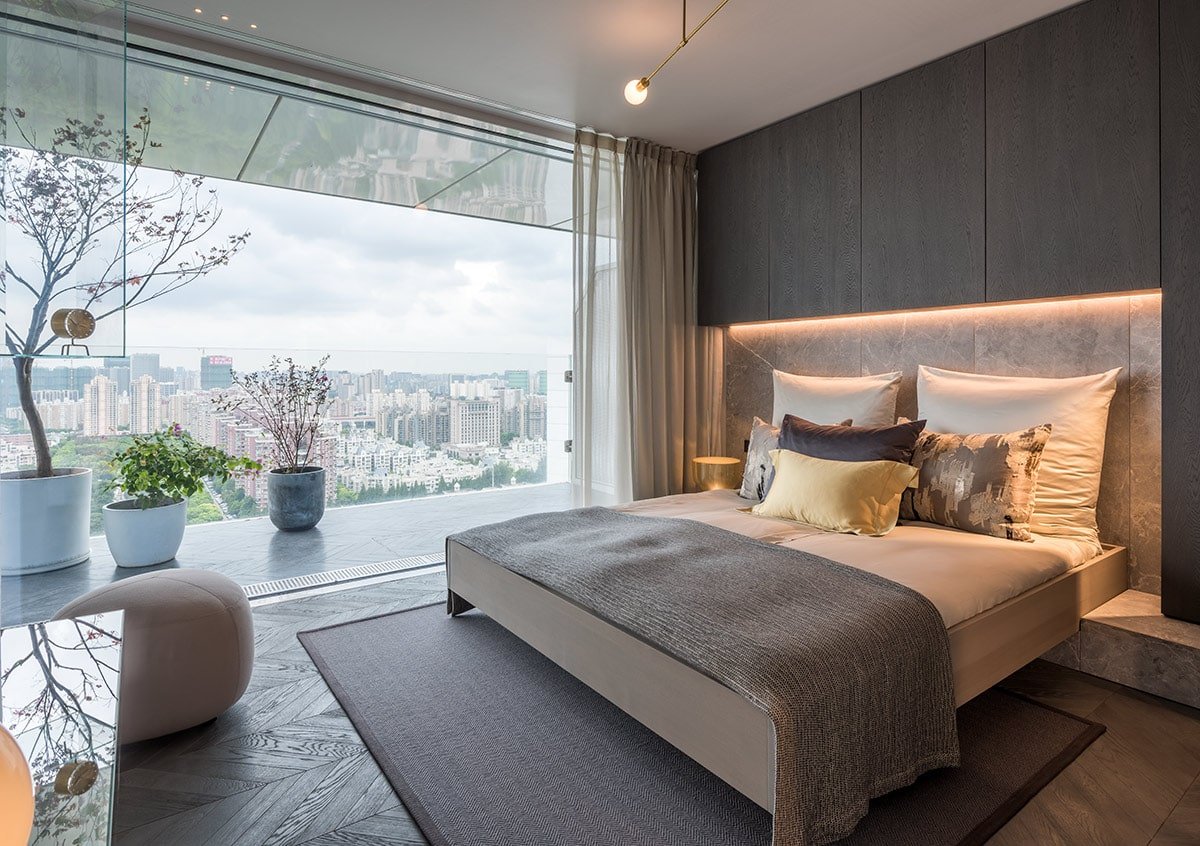 The bedroom's large floor-to-ceiling window provides unrestricted views of the city.