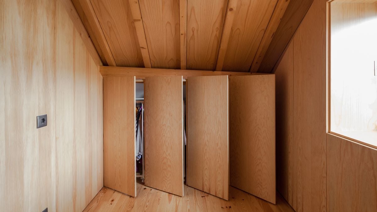 A clothing room is located on the opposite side of the staircase, and it is flanked by a bathroom.