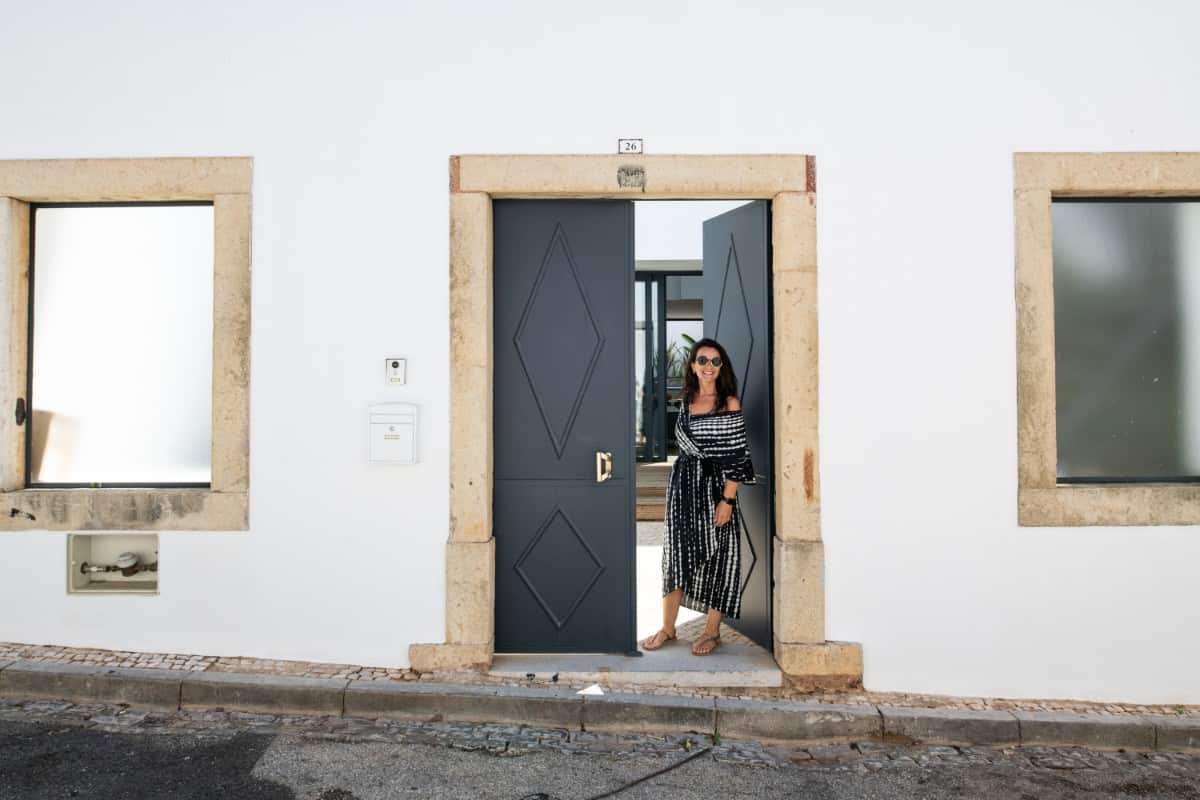 The home features gray double doors with diamond patterns and wooden frame.