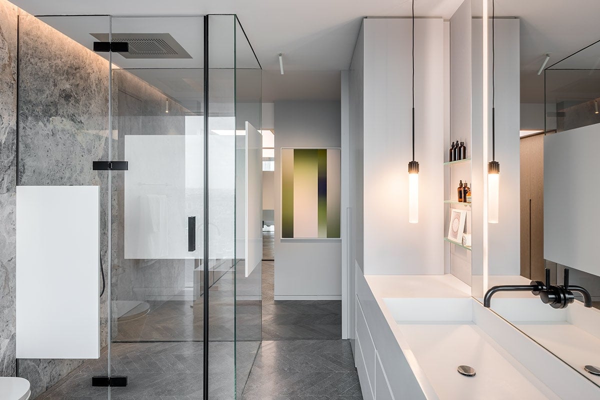 A bathroom with grainy Chinese marble as the major wall covering with black and gold accessories.