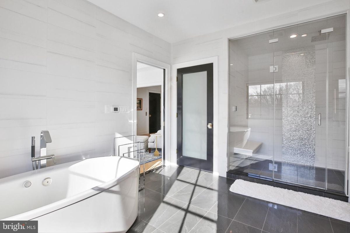 The elegant glass door of the shower enclosure adds a touch of sophistication to the bathroom, while the refreshing rainfall shower provides a rejuvenating and spa-like experience.