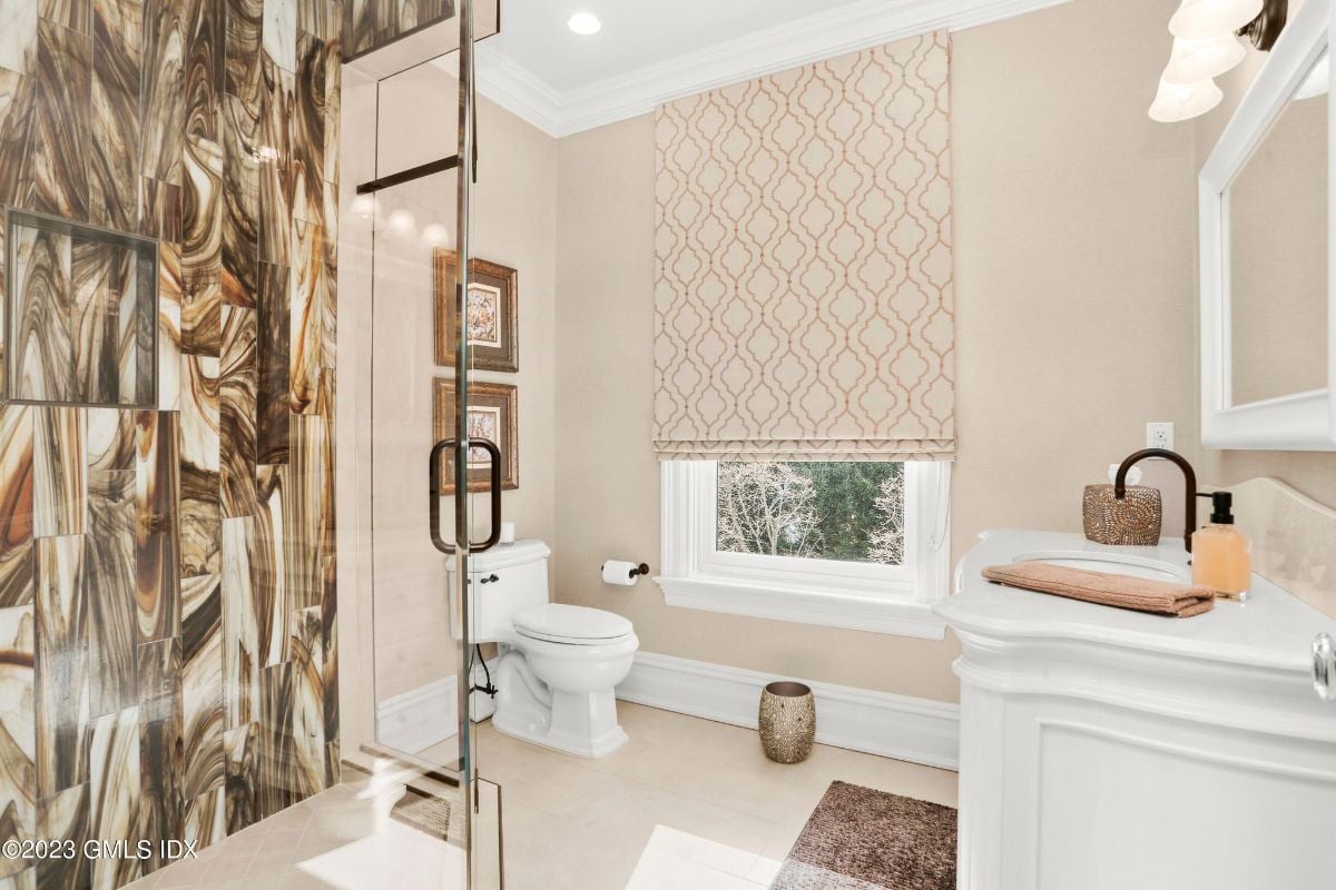 The modern bathroom featured a sleek shower cubicle with glass doors, offering a luxurious and invigorating showering experience, while the toilet was discreetly positioned in a separate area, providing privacy and functionality.