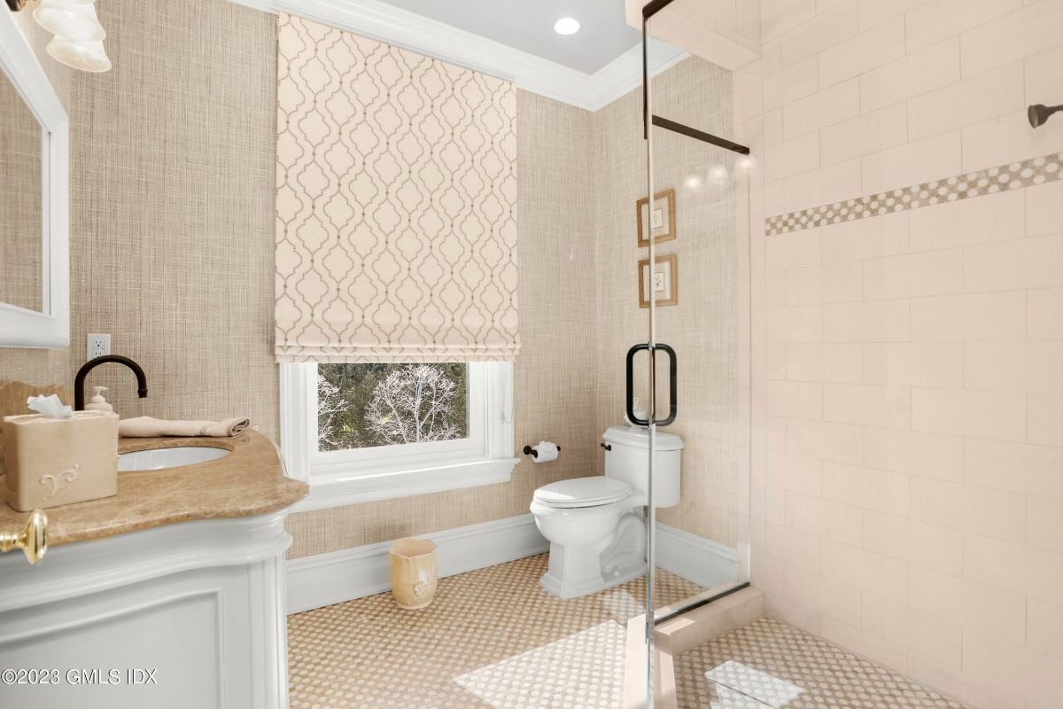 The stunning bathroom boasted a spacious shower cubicle, complete with sleek glass doors, while the elegant vanity offered ample storage space and a stunning design that perfectly complemented the modern aesthetic of the space.
