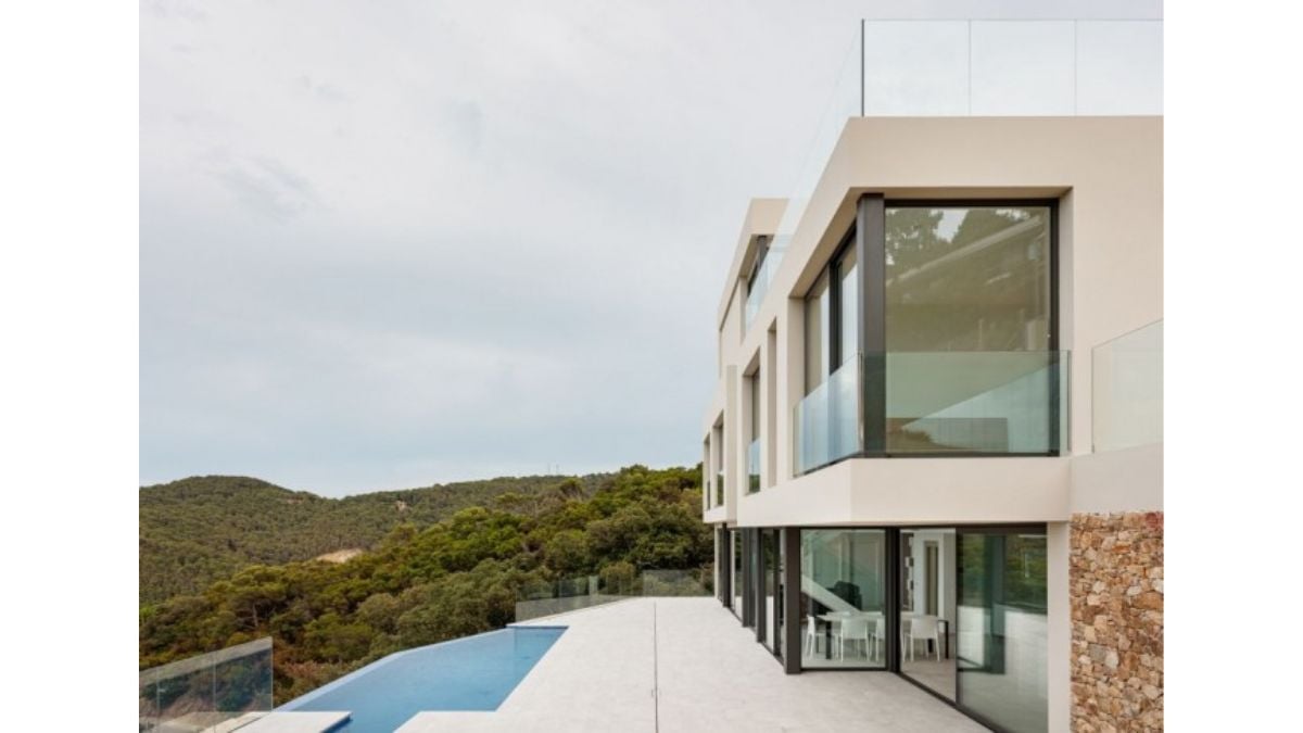 An insulated, single-family home on a hillside with a swimming pool.